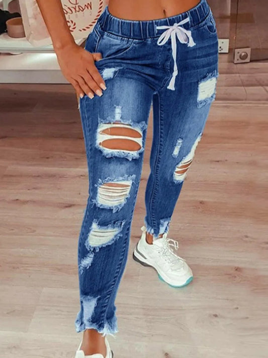 Vaqueros desgastados, elásticos y con bordes sin rematar, con cremallera y agujeros lisos, ropa de calle de mezclilla de moda.